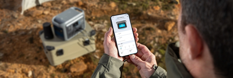 Anker SOLIX Powerstation und Smartphone im Einsatz im Freien.