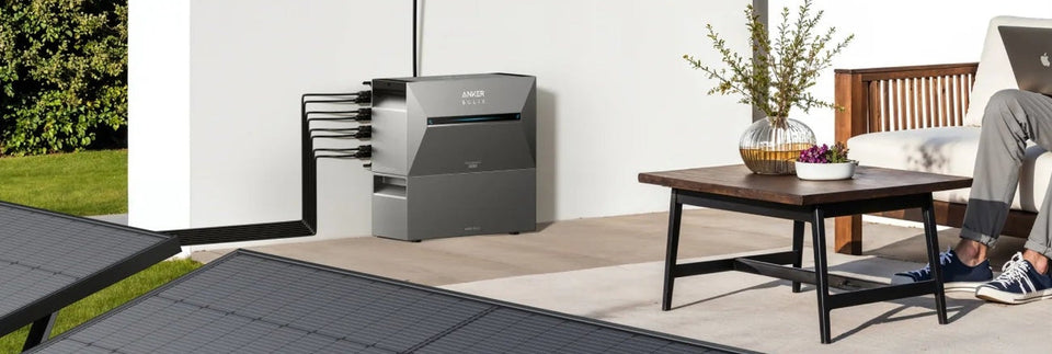 Anker SOLIX Solarbank mit Zusatzbatterie auf einer Terrasse.