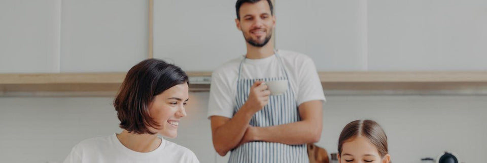 Familie bei der Zubereitung einer Mahlzeit in der Küche.