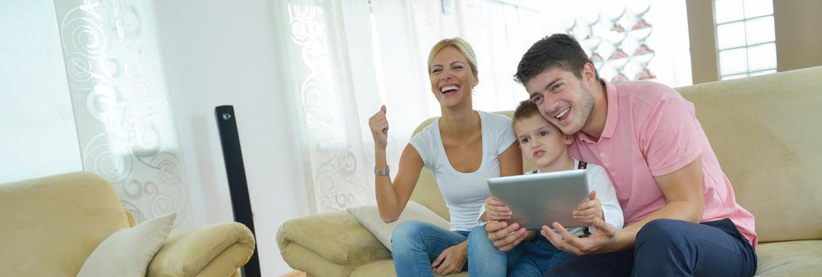 Familie mit Tablet im Wohnzimmer.