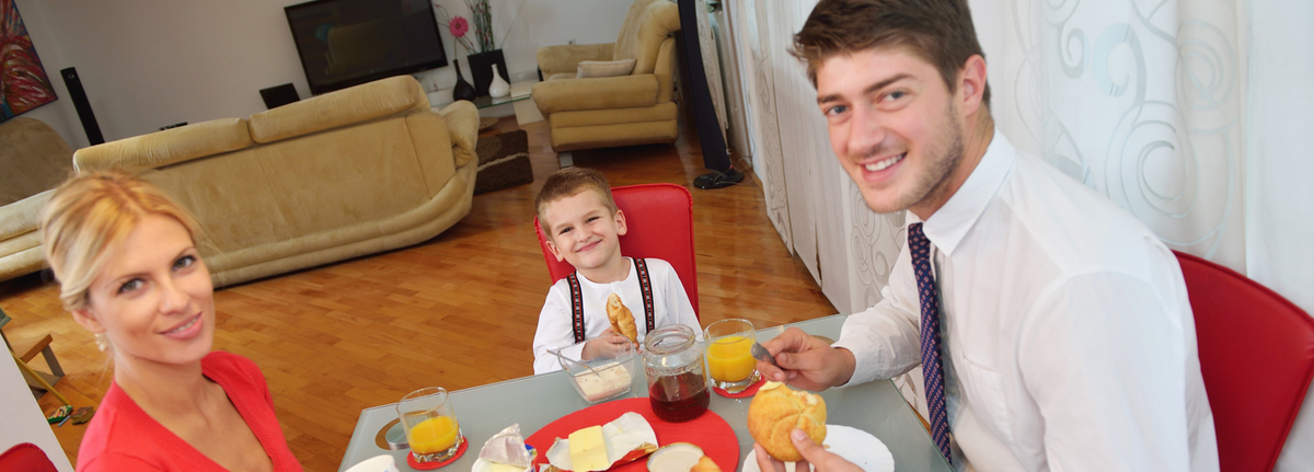 Familie beim gemeinsamen Frühstück zu Hause.