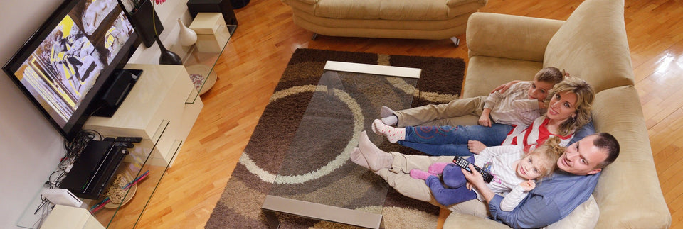 Familie auf einem Sofa im Wohnzimmer.