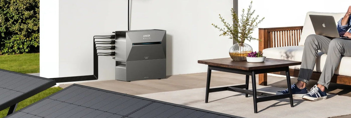 Anker SOLIX Solarbank mit Zusatzbatterie auf einer Terrasse.
