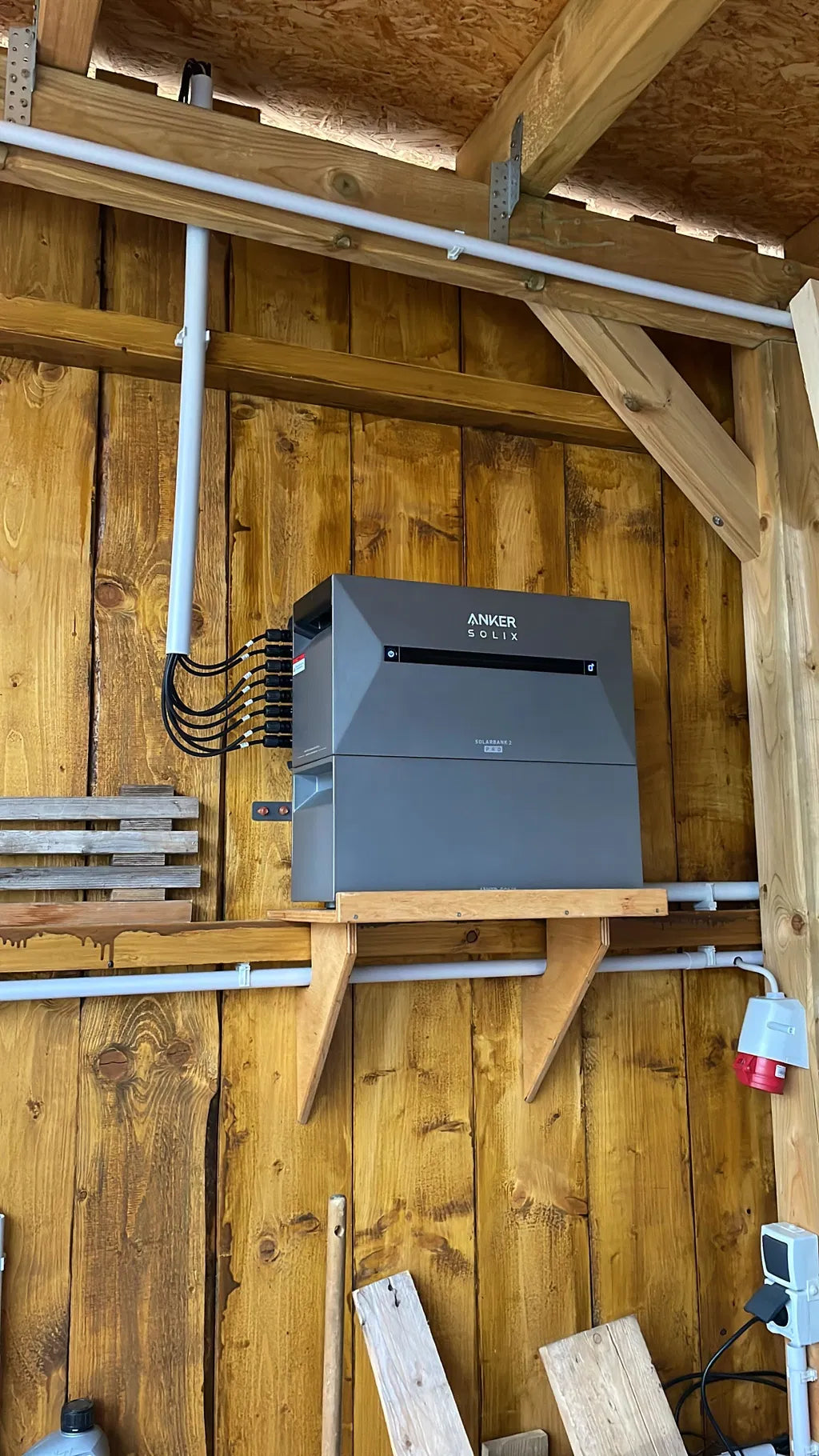 Anker SOLIX Solarbank 2 Pro mit Verkabelung an einer Holzwand
