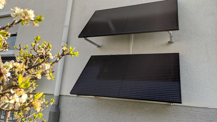 Vier Solarmodule an der Fassade eines Wohnhauses
