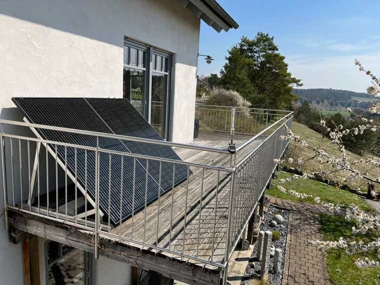 Solarmodule auf einer Balkonhalterung an einem Wohnhaus